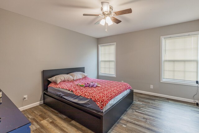 bedroom with ceiling fan and dark hardwood / wood-style flooring