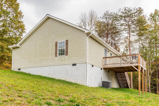 view of side of home featuring central AC unit, a wooden deck, and a yard