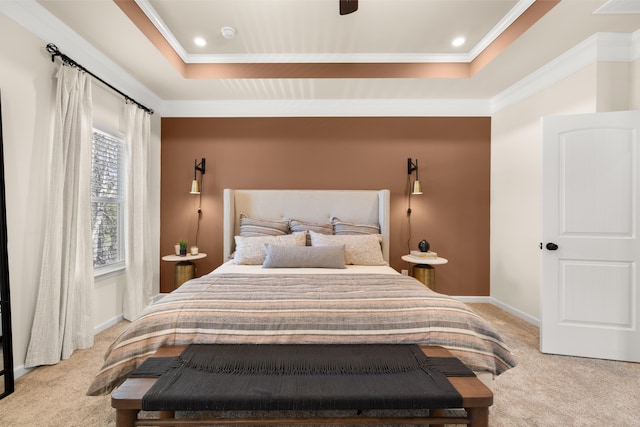 carpeted bedroom with a raised ceiling, ceiling fan, and crown molding