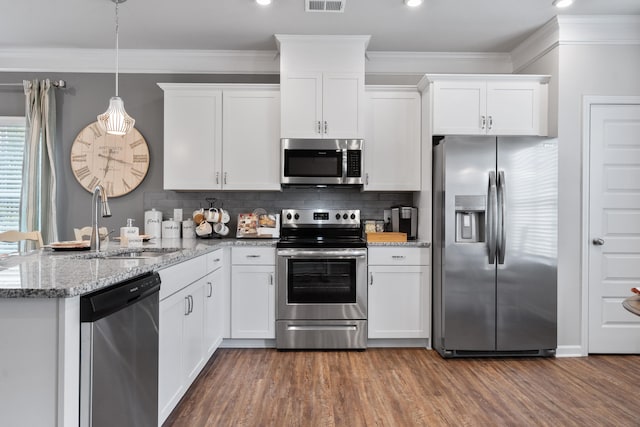 kitchen featuring stainless steel appliances, dark hardwood / wood-style flooring, hanging light fixtures, sink, and white cabinets