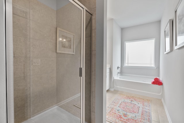 bathroom with tile patterned flooring and separate shower and tub