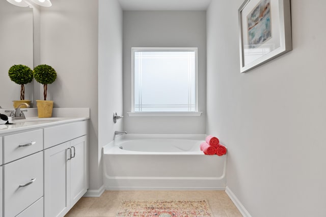 bathroom featuring tile patterned flooring, a washtub, and vanity