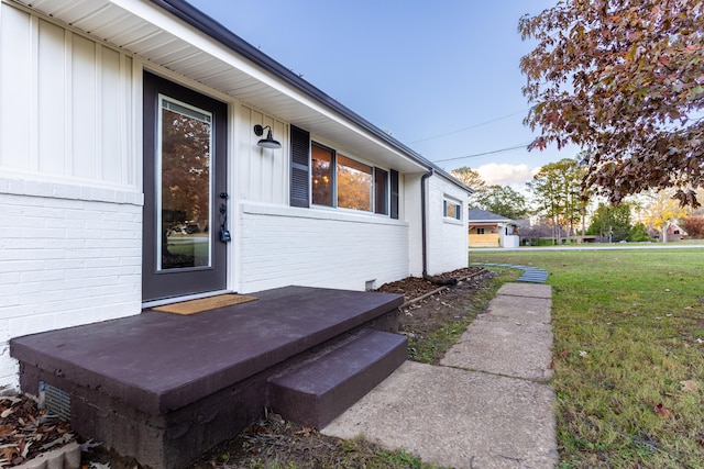 property entrance featuring a lawn