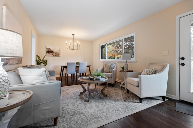 living room with dark hardwood / wood-style floors and a notable chandelier