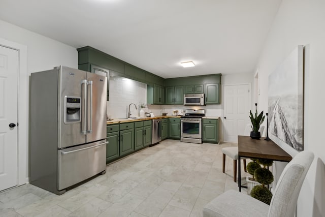 kitchen featuring sink, green cabinetry, and appliances with stainless steel finishes