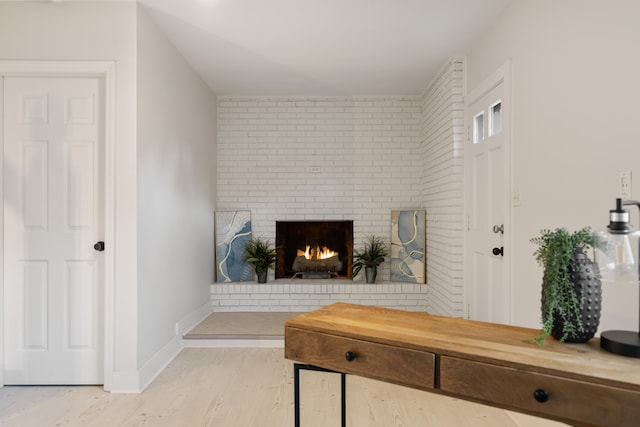 living room featuring light hardwood / wood-style floors and a brick fireplace