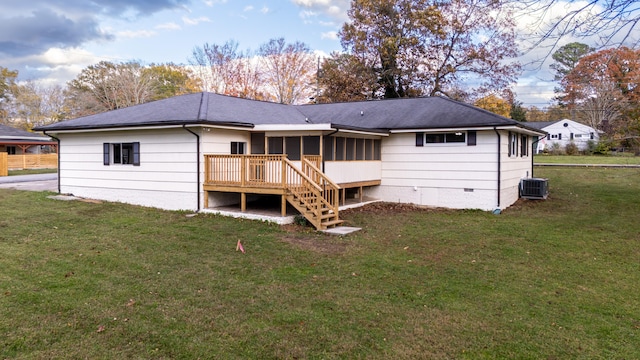 rear view of property with a yard, a sunroom, cooling unit, and a wooden deck