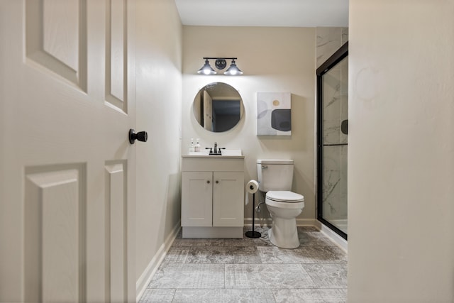 bathroom featuring a shower with door, vanity, and toilet