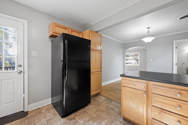 kitchen with light brown cabinetry, black fridge, plenty of natural light, and hanging light fixtures