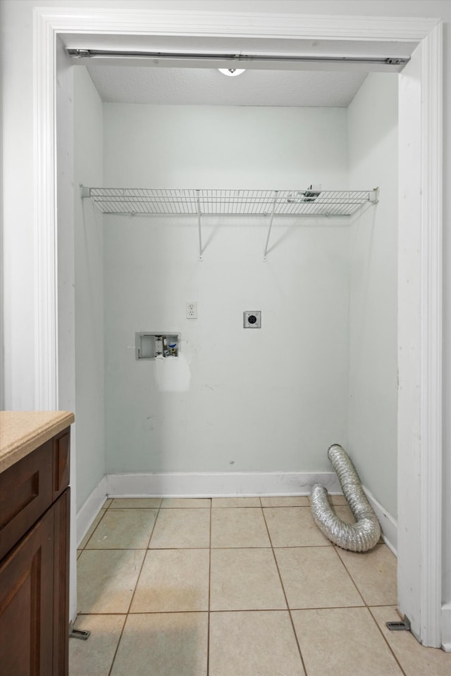 clothes washing area with electric dryer hookup, light tile patterned floors, and hookup for a washing machine