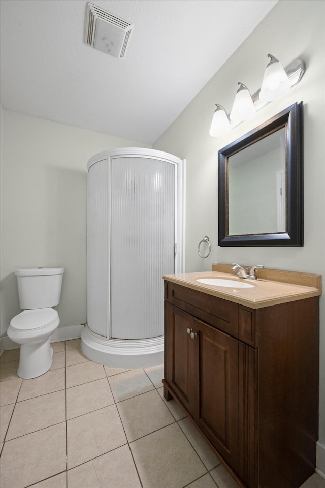 bathroom featuring tile patterned flooring, vanity, toilet, and a shower with shower door