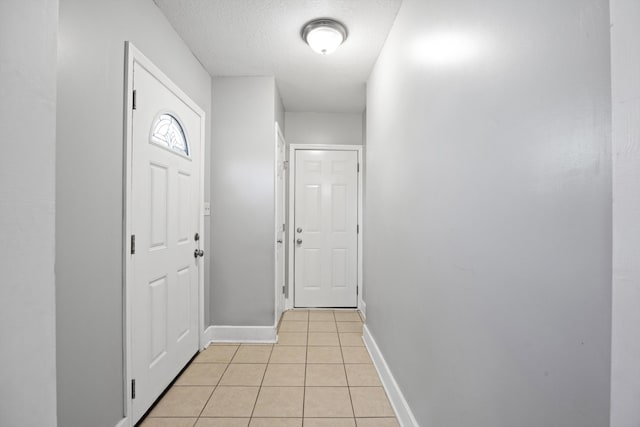 interior space featuring light tile patterned floors and a textured ceiling