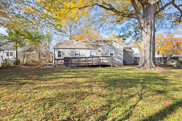 back of property featuring a lawn and a wooden deck