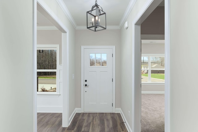 foyer entrance featuring dark hardwood / wood-style flooring, an inviting chandelier, and crown molding