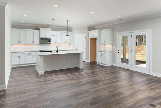 kitchen with white cabinetry, decorative light fixtures, dark hardwood / wood-style floors, and light stone counters