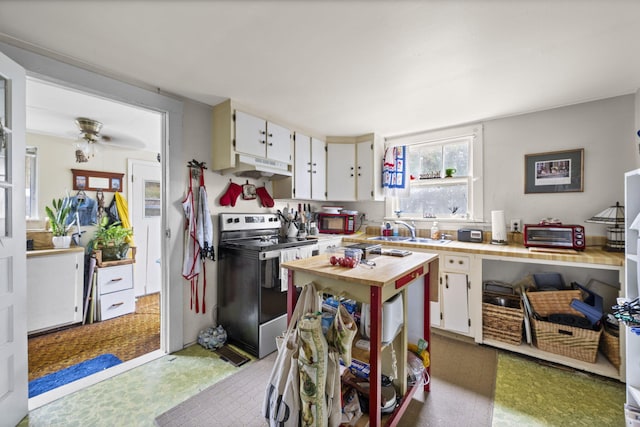 kitchen with white cabinets, sink, ceiling fan, and electric range