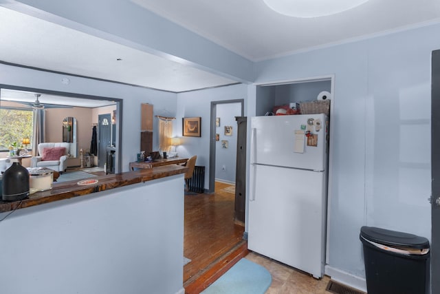 kitchen with hardwood / wood-style flooring, ceiling fan, white fridge, and ornamental molding