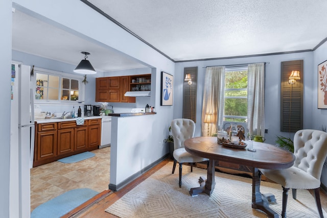 dining space with a textured ceiling and crown molding