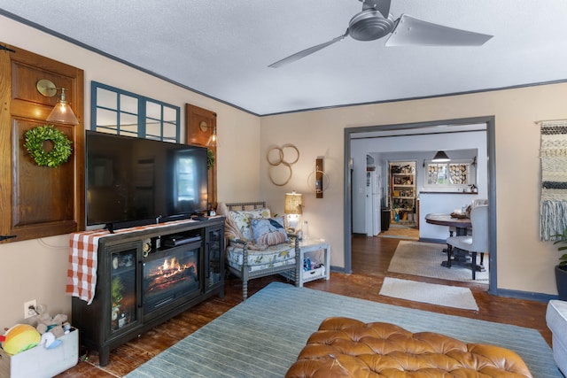 living room with dark wood-type flooring, ceiling fan, and a textured ceiling