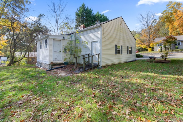 rear view of house featuring a lawn