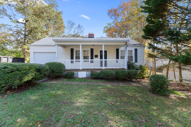 view of front of house with a front lawn, a garage, and a porch