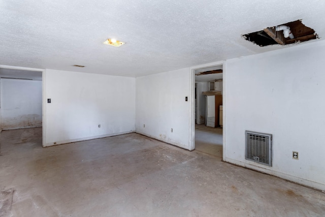 interior space featuring heating unit and a textured ceiling