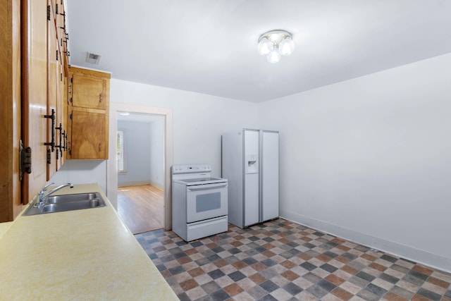 kitchen with dark hardwood / wood-style flooring, white appliances, and sink