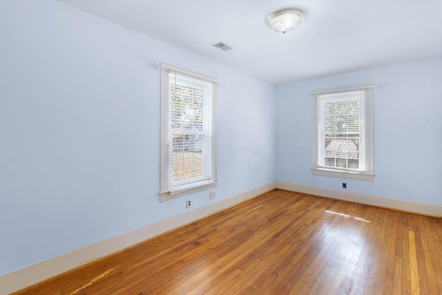 unfurnished room with hardwood / wood-style flooring and plenty of natural light