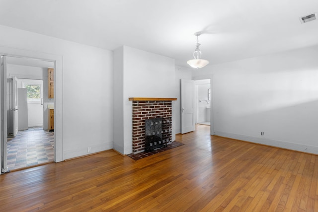 unfurnished living room featuring wood-type flooring and a fireplace