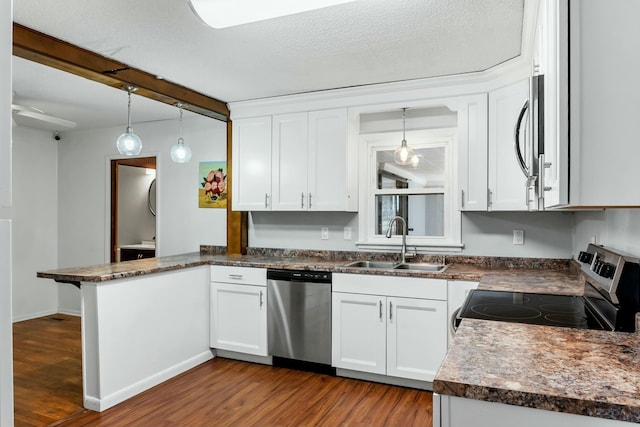 kitchen featuring pendant lighting, white cabinetry, kitchen peninsula, and stainless steel appliances