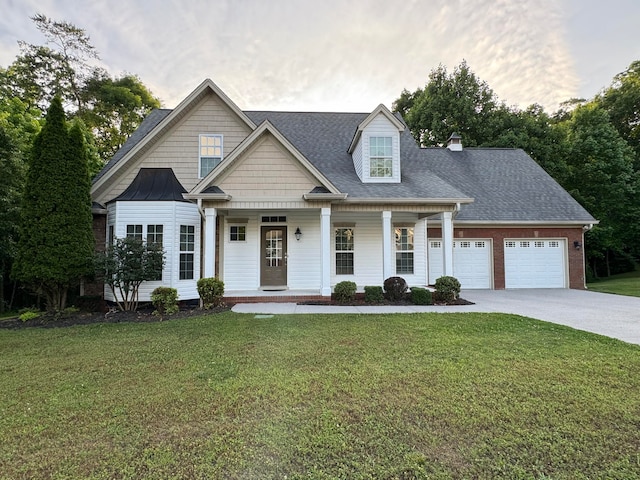 view of front of house featuring a front lawn, covered porch, and a garage