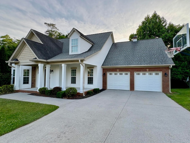 view of front of home with covered porch, a garage, and a front lawn