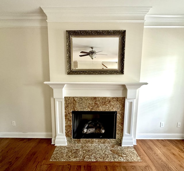 room details featuring a high end fireplace, hardwood / wood-style flooring, ceiling fan, and crown molding