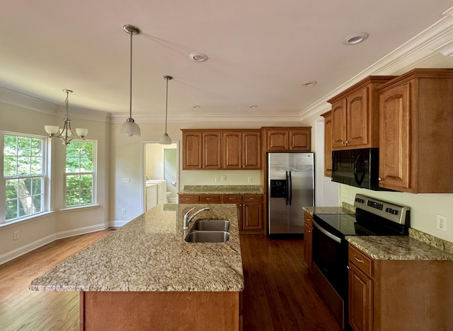 kitchen with a kitchen island with sink, an inviting chandelier, sink, appliances with stainless steel finishes, and dark hardwood / wood-style flooring