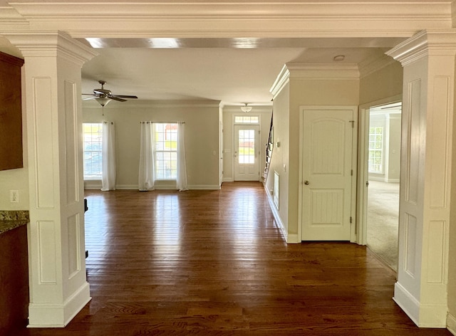 interior space featuring ornate columns, ceiling fan, dark wood-type flooring, and ornamental molding