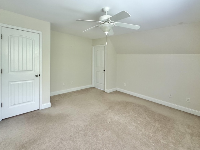 additional living space with light carpet, ceiling fan, and vaulted ceiling