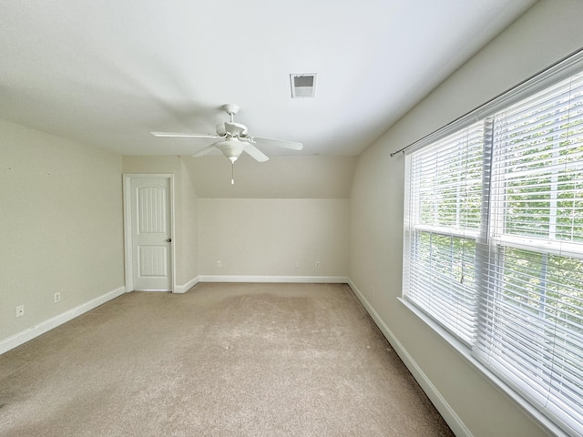 additional living space featuring light colored carpet, vaulted ceiling, and ceiling fan