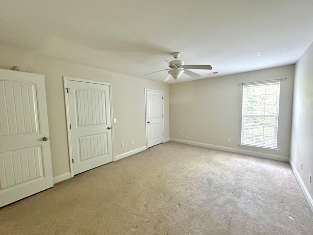 unfurnished bedroom with light carpet and ceiling fan