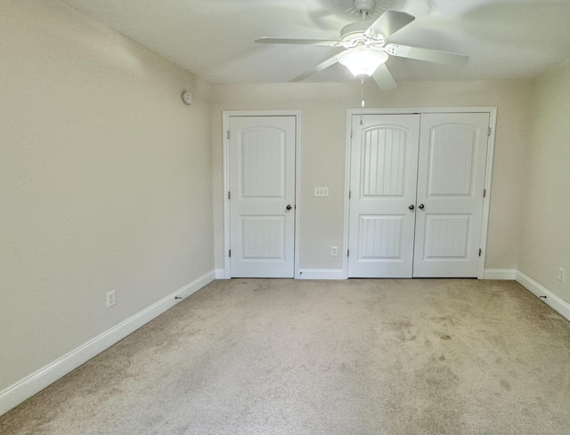 unfurnished bedroom with ceiling fan, a closet, and light carpet