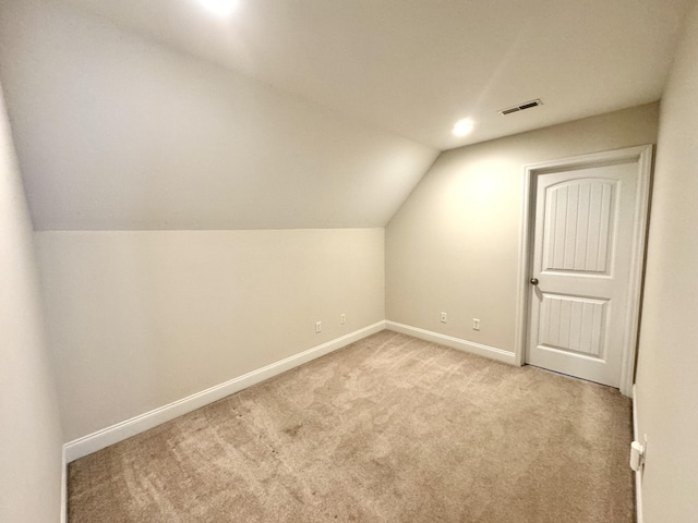 bonus room with light colored carpet and lofted ceiling