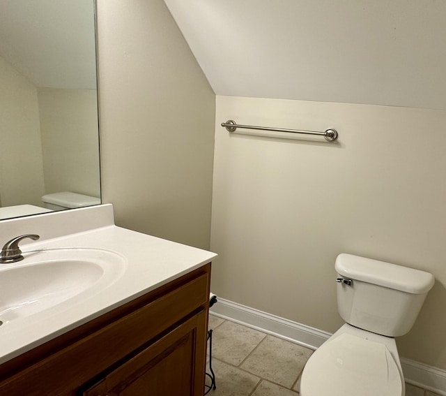 bathroom featuring tile patterned flooring, vanity, toilet, and lofted ceiling