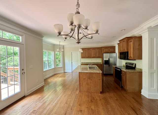 kitchen with stainless steel appliances, crown molding, decorative light fixtures, light hardwood / wood-style floors, and an island with sink