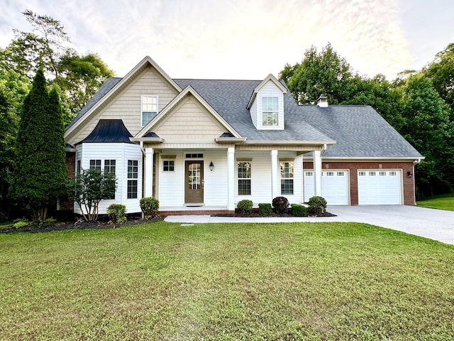 view of front of house featuring a porch, a garage, and a front lawn