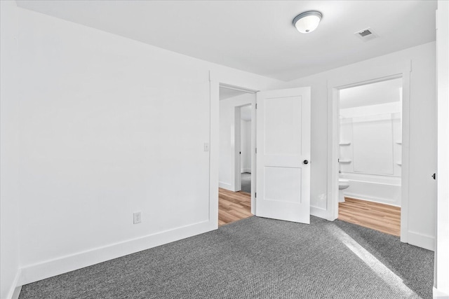 unfurnished bedroom featuring connected bathroom, a closet, a spacious closet, and carpet floors