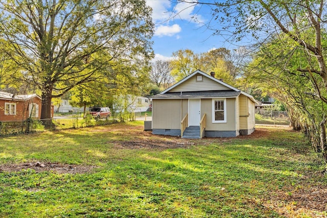 back of property featuring an outdoor structure and a yard