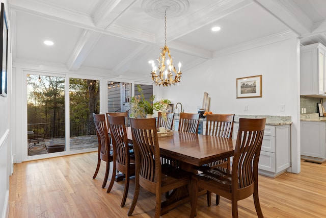 dining room featuring light wood-type flooring, a notable chandelier, crown molding, and beam ceiling