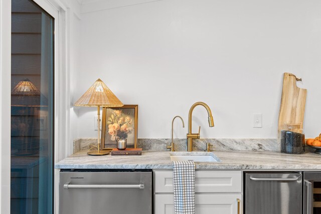 interior space featuring dishwasher, white cabinetry, and sink