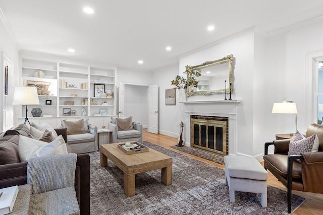 living room featuring a fireplace, wood-type flooring, and crown molding