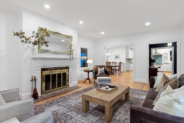 living room with a brick fireplace, hardwood / wood-style floors, and crown molding