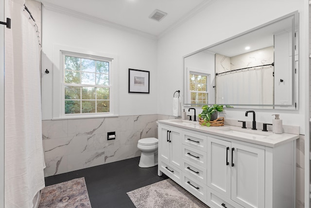 bathroom with tile walls, ornamental molding, a healthy amount of sunlight, and vanity